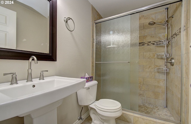 bathroom with tile patterned flooring, toilet, a shower with door, and sink