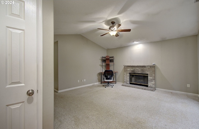 unfurnished living room featuring lofted ceiling, ceiling fan, carpet floors, and a brick fireplace