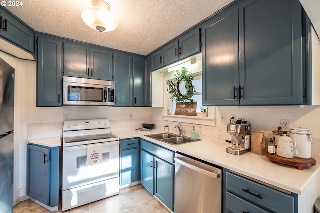 kitchen featuring a textured ceiling, sink, blue cabinets, and stainless steel appliances