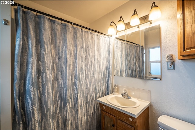 bathroom featuring a shower with curtain, vanity, and toilet