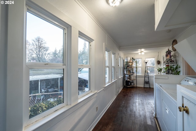 hallway featuring washer and dryer, dark hardwood / wood-style flooring, ornamental molding, and a textured ceiling