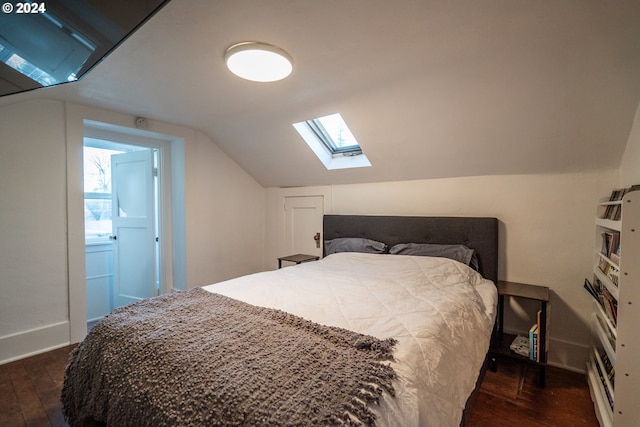 bedroom featuring ensuite bathroom, dark hardwood / wood-style flooring, and lofted ceiling