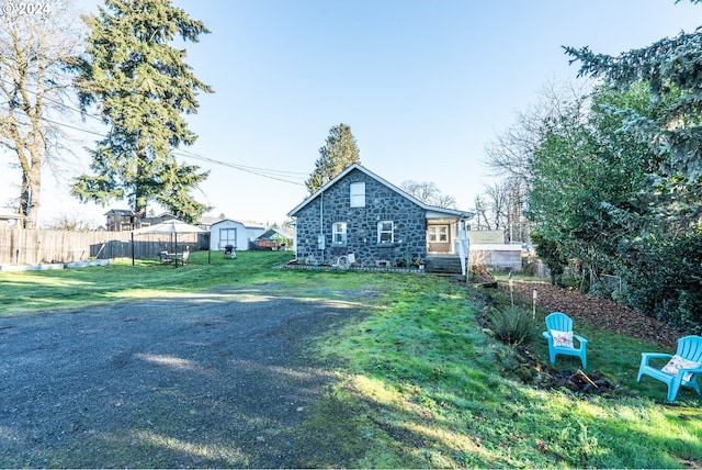 view of side of home with a storage unit and a lawn