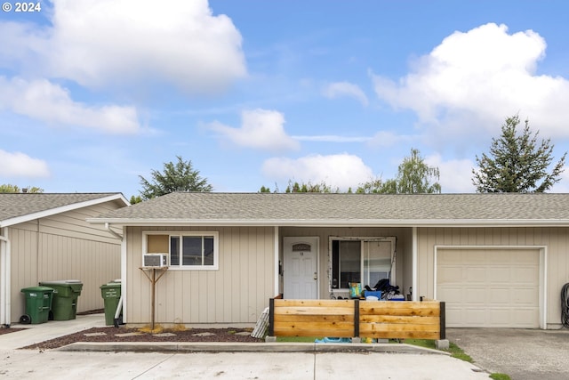 single story home featuring a garage, cooling unit, roof with shingles, and aphalt driveway