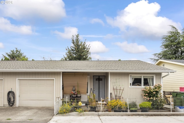 ranch-style home with a garage, roof with shingles, and driveway