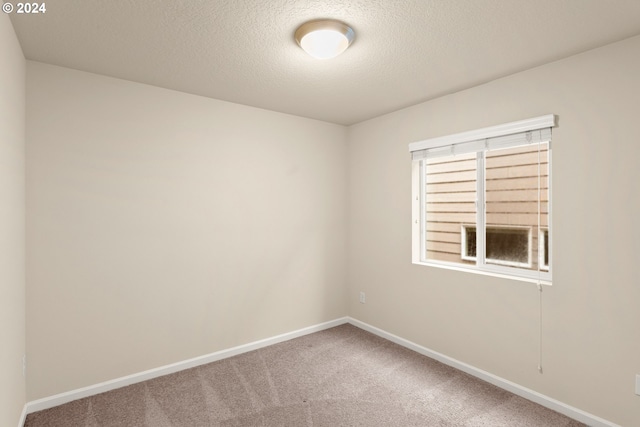 carpeted spare room featuring a textured ceiling