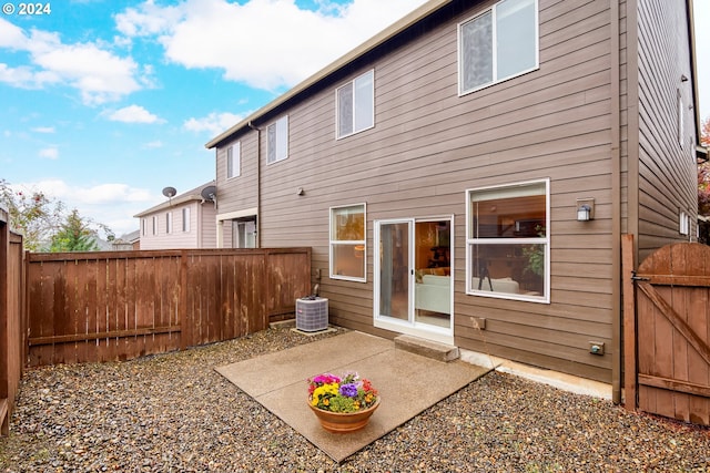 rear view of house with central air condition unit and a patio area