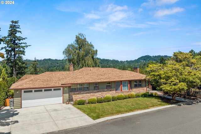 ranch-style house featuring a front yard and a garage