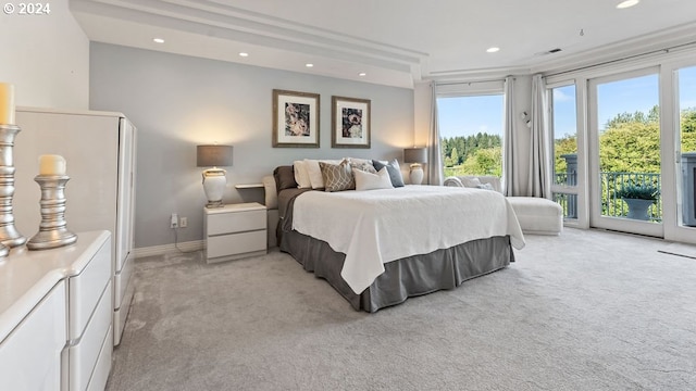 bathroom with a wealth of natural light, ornamental molding, and a relaxing tiled tub