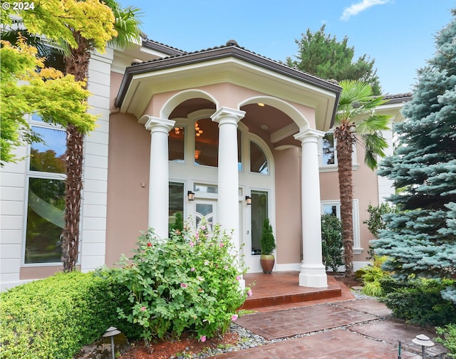 dining space with a healthy amount of sunlight, an inviting chandelier, and ornate columns