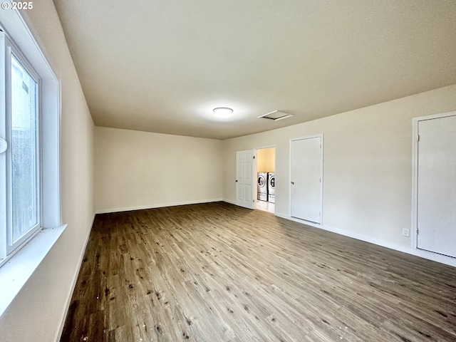 spare room featuring hardwood / wood-style flooring, plenty of natural light, and separate washer and dryer