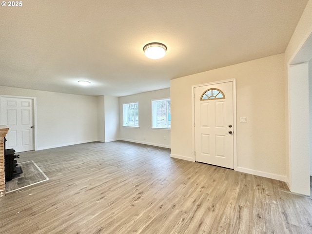 entrance foyer featuring a wood stove and light hardwood / wood-style flooring