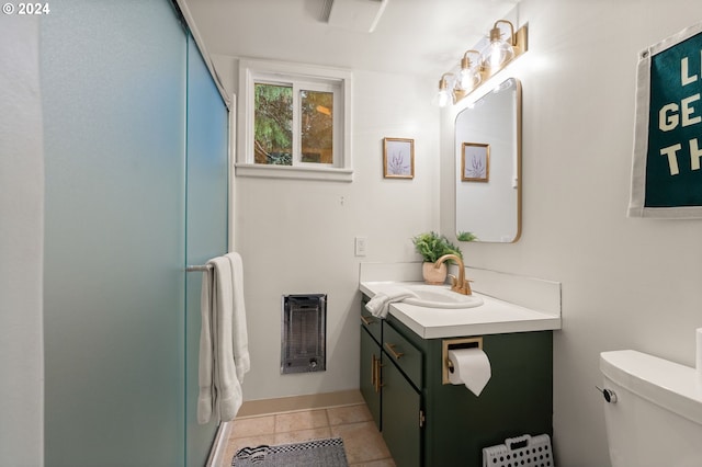 bathroom with heating unit, toilet, walk in shower, vanity, and tile patterned floors