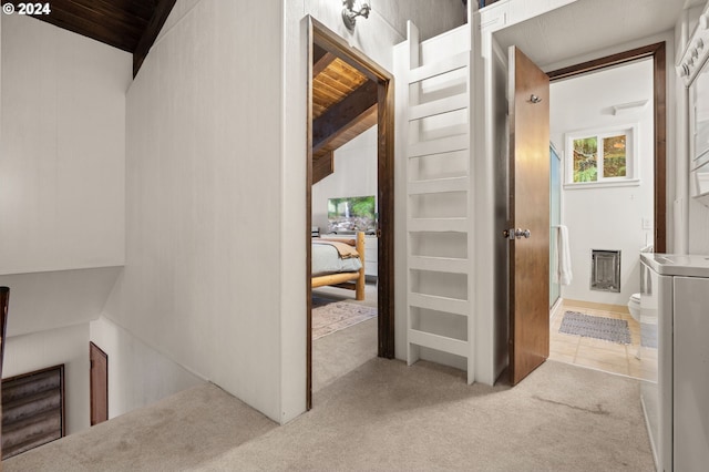 corridor with lofted ceiling, light colored carpet, wooden ceiling, and washer / clothes dryer