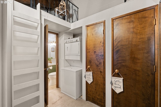 clothes washing area with light carpet and stacked washer and dryer