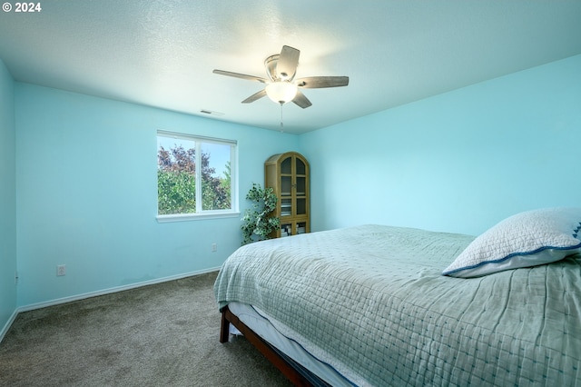 carpeted bedroom with ceiling fan, visible vents, baseboards, and a textured ceiling