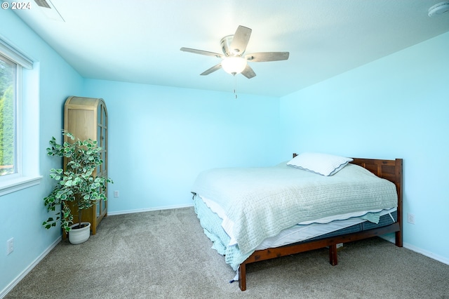 bedroom with light carpet, multiple windows, a ceiling fan, and baseboards