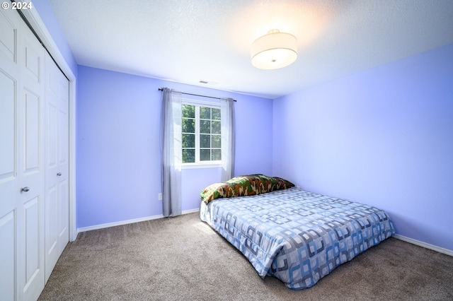 bedroom featuring carpet, a closet, visible vents, and baseboards