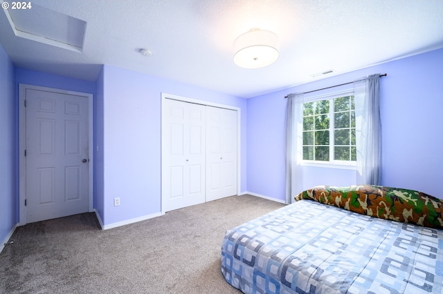 unfurnished bedroom featuring carpet floors, attic access, visible vents, and baseboards