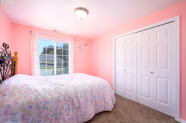 bedroom with carpet, visible vents, and a closet