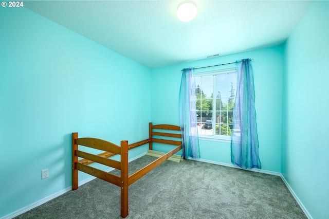 unfurnished bedroom featuring carpet, visible vents, and baseboards