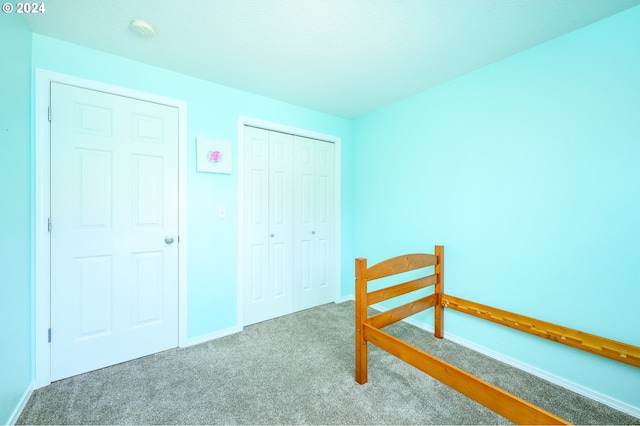 unfurnished bedroom featuring a closet, carpet, and baseboards