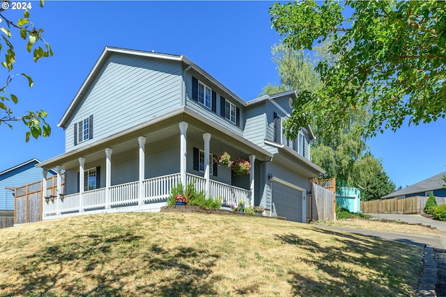 view of front of house featuring a porch, an attached garage, a front lawn, and fence