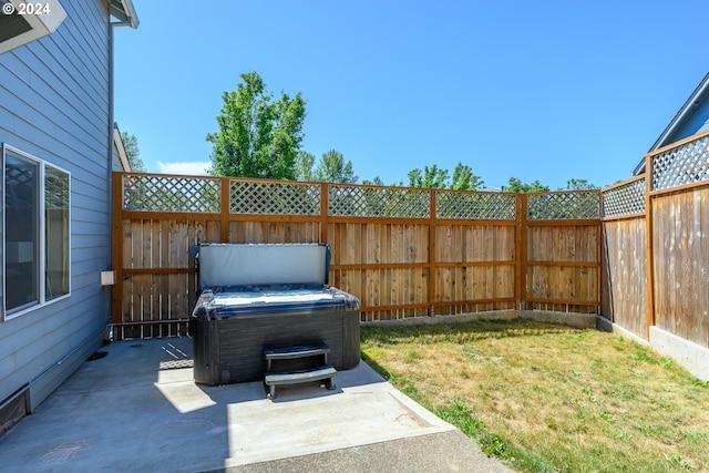 view of yard with a hot tub, a fenced backyard, and a patio