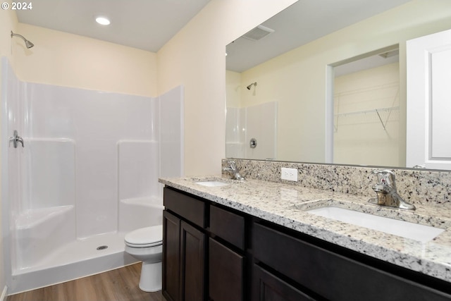 bathroom featuring toilet, walk in shower, hardwood / wood-style flooring, and vanity