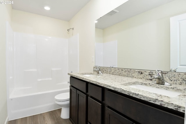 full bathroom with wood-type flooring, toilet, shower / washtub combination, and vanity