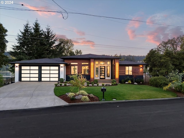 prairie-style home with a yard and a garage