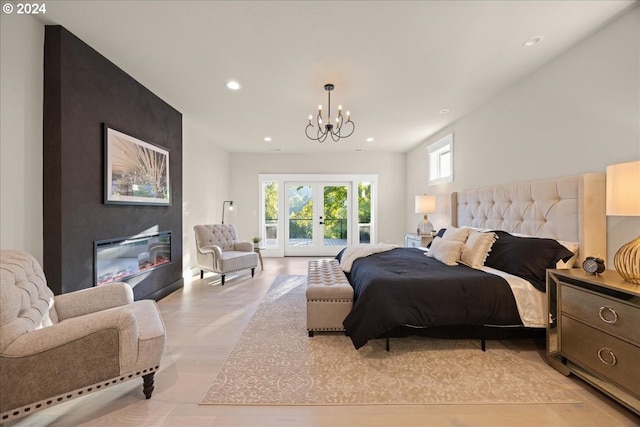 bedroom featuring an inviting chandelier, recessed lighting, french doors, a glass covered fireplace, and access to outside