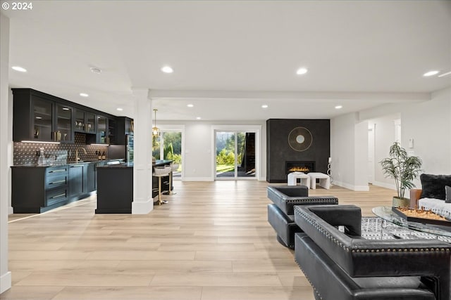 living area featuring recessed lighting, baseboards, light wood-style floors, and a fireplace