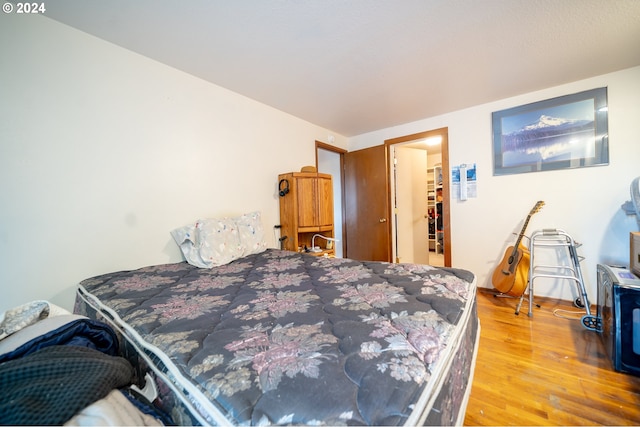 bedroom featuring a walk in closet and hardwood / wood-style floors