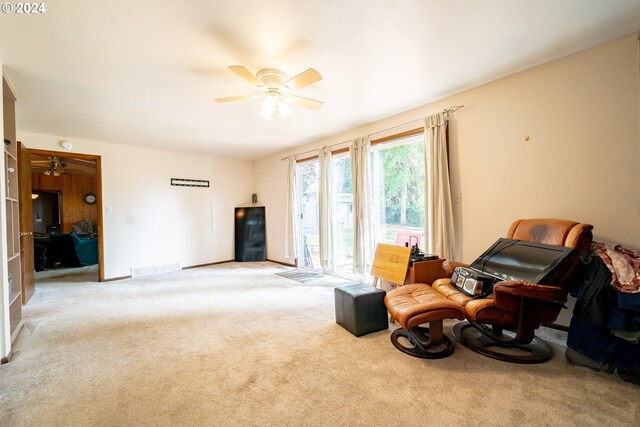 sitting room featuring light colored carpet and ceiling fan