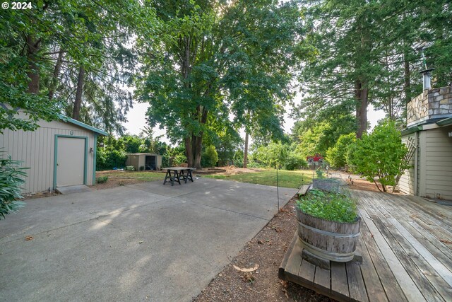 view of patio with a wooden deck and an outdoor structure