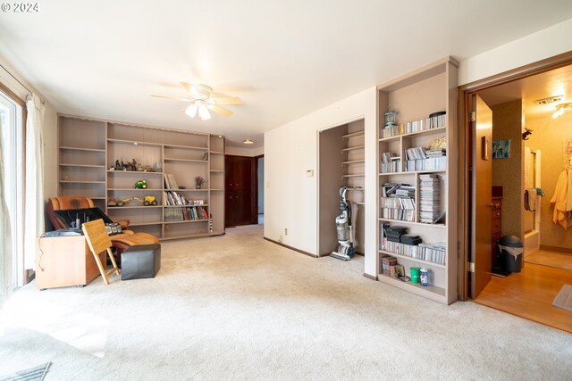 living area featuring carpet flooring and ceiling fan