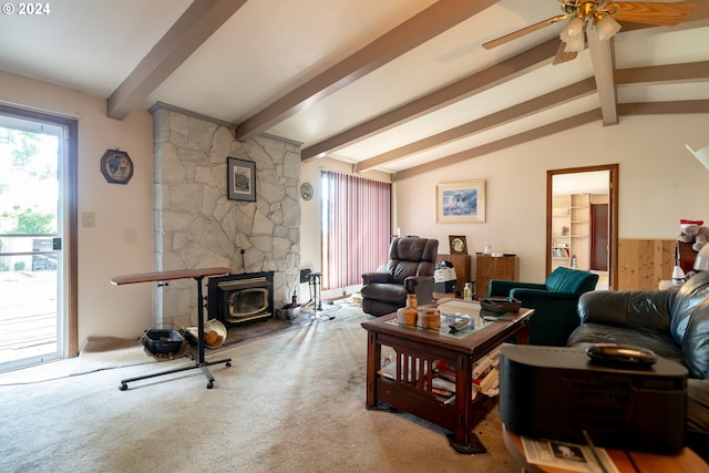 carpeted living room featuring a wood stove, ceiling fan, a fireplace, and lofted ceiling with beams