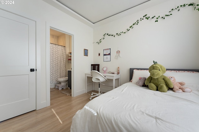 bedroom featuring ensuite bath and light wood-type flooring