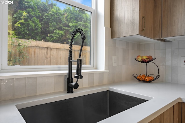 details featuring tasteful backsplash and sink