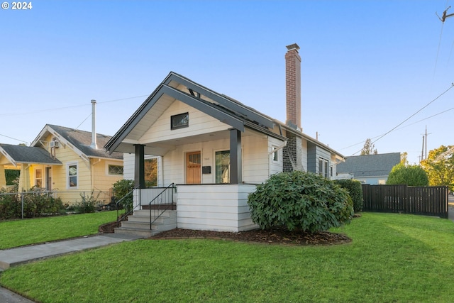 bungalow-style house with covered porch and a front yard