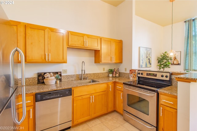 kitchen with appliances with stainless steel finishes, a healthy amount of sunlight, sink, and light stone counters