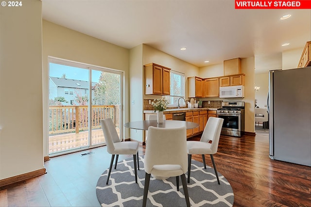 dining area with plenty of natural light and dark wood-type flooring