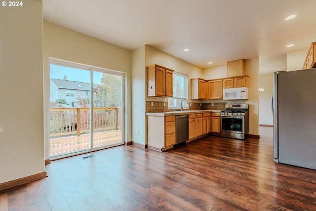 kitchen featuring stainless steel appliances, dark wood-type flooring, and sink