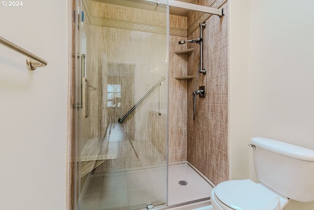 bathroom featuring toilet and a shower with door