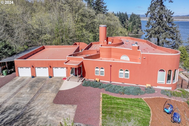 view of front of property featuring a front yard, a water view, and a garage