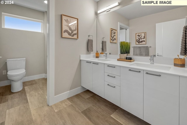 bathroom with toilet and dual bowl vanity