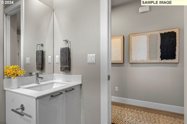 bathroom featuring wood-type flooring and large vanity