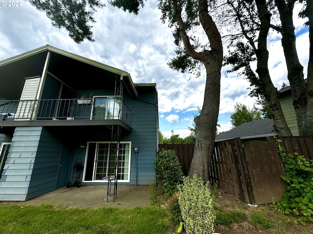 rear view of house featuring a balcony and a patio