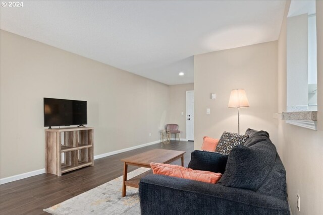 living room featuring a tile fireplace, ceiling fan, and dark hardwood / wood-style floors